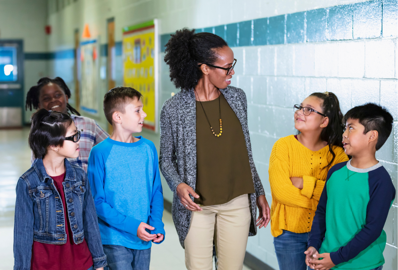 Teacher with students in school hallway