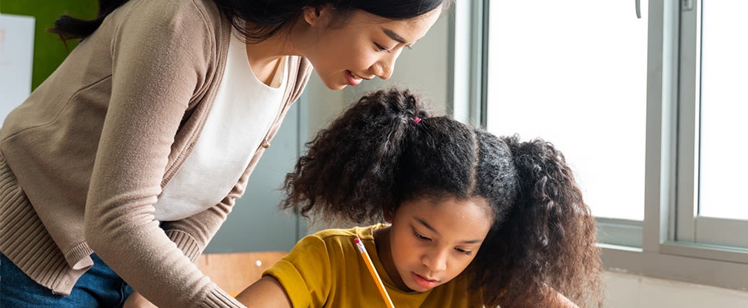 Teacher and student working together at a desk